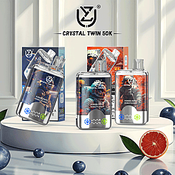 Display of Crystal Twin 50K vape devices with 50,000 puffs featuring colorful space-themed designs and packaged boxes in a bright setting with fruit accents.